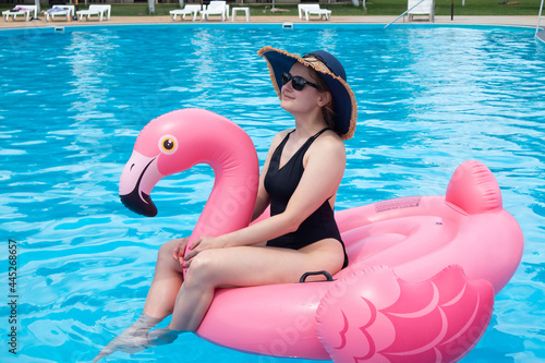 Happy woman on flamingo pool float in pool. Summer holidays © Marharyta