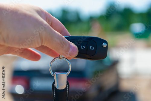 Car keys and car in the background. Sale, purchase of a car.