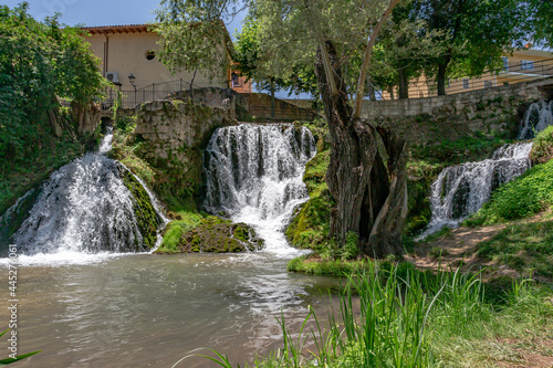 Waterfalls from the Cifuentes river as it passes through the town of Trillo. Wild river. Urban waterfalls.