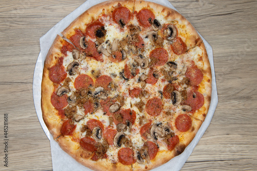 Overhead view of melted cheeses covers this mushroom and pepperoni pizza with the crispy crust cooked to perfection