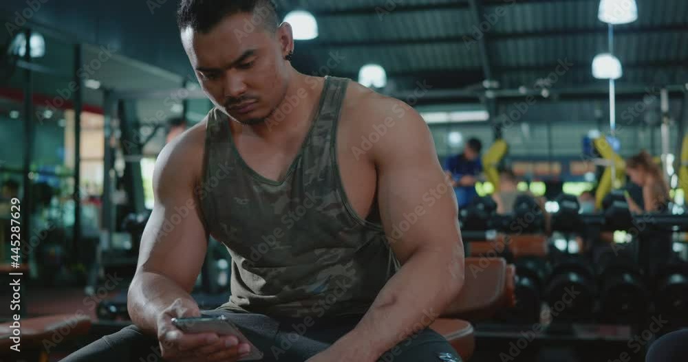 Active young man break sitting using smartphone after workout training exercise in fitness club gym, Sport healthy lifestyle technology concept Active young man break sitting using smartphone after workout training exercise in fitness club gym, Sport healthy lifestyle technology concept
