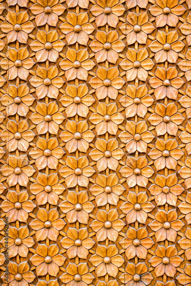 Fototapeta premium Fragment of a carved wooden door with a carved embossed floral ornament