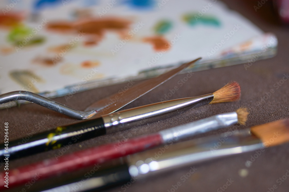 Table with brushes and canvas in an art workshop. Background.