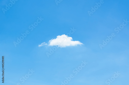 Single white cloud stay alone in bright blue sky in summertime.