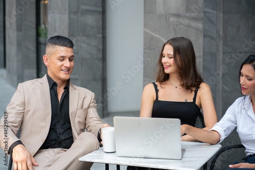 Group of Business People Drinking Coffee and Discussion with Laptop Computer at Coffee Shop in Breaking time