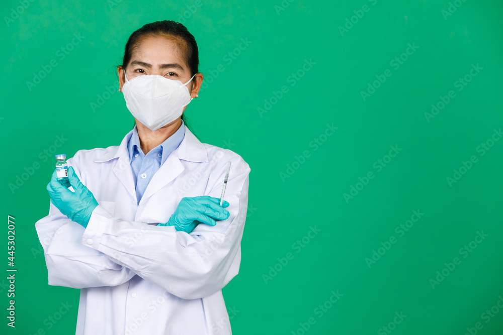 Asian female doctor wearing lab coat and mask holding syringe and Covid 19 vaccine. Concept for Covid 19 vaccination Asian female doctor wearing lab coat and mask holding syringe and Covid 19 vaccine. Concept for Covid 19 vaccination