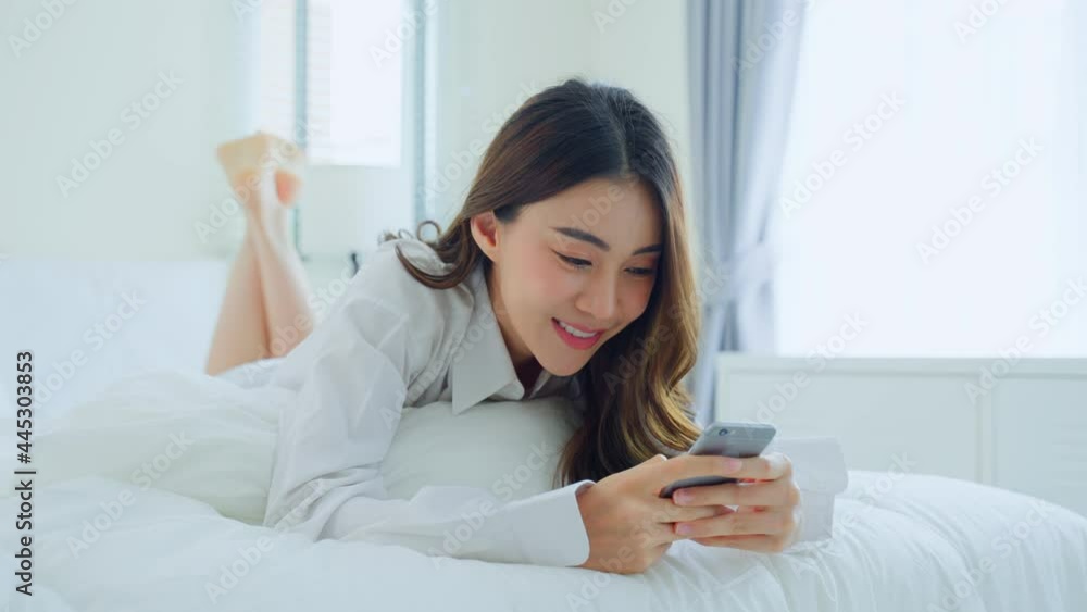 Asian attractive woman use mobile phone chat on bed at home in morning Asian attractive woman use mobile phone chat on bed at home in morning