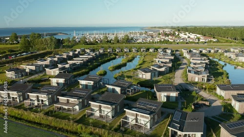 Eco-friendly Bungalow Houses With Solar Panels On Roofs At The Coastline Of Kamperland. Roompot Water Village In Zeeland, Netherlands. aerial photo