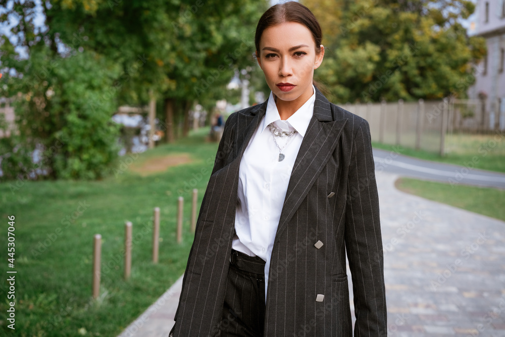 Woman's portrait on the street of the city. Business young woman of Caucasian ethnicity in a suit and white shirt posing. Successful woman concept Woman's portrait on the street of the city. Business young woman of Caucasian ethnicity in a suit and white shirt posing. Successful woman concept