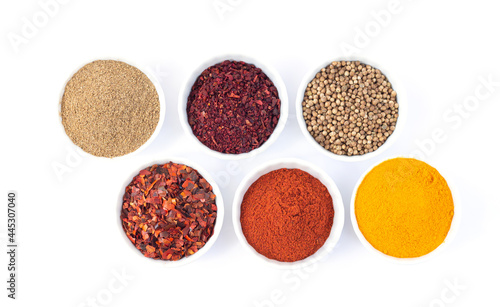 Bowls of different seasoning organic spices isolated on white