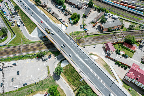 aerial view of road bridge and rail tracks. road intersection in urban industrial district.
