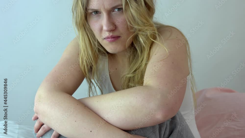 Depressed crying woman sits on the bed and cries. The woman feels emotional and psychological pain, she is sick. She suffers a lot, feels fear and anxiety. Depressed crying woman sits on the bed and cries. The woman feels emotional and psychological pain, she is sick. She suffers a lot, feels fear and anxiety.