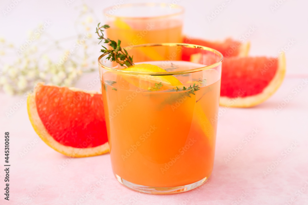 Glasses of tasty grapefruit juice on light background Glasses of tasty grapefruit juice on light background