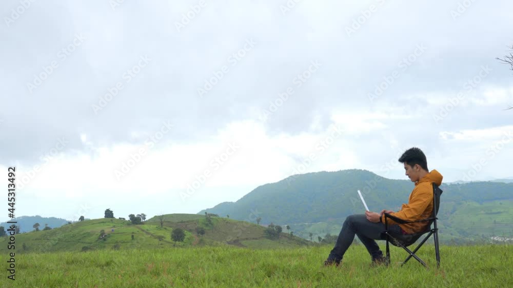 Asian businessman working on laptop computer for online stock trading or small business on the mountain. Modern handsome man enjoy outdoor lifestyle with using wireless technology on summer vacation. Asian businessman working on laptop computer for online stock trading or small business on the mountain. Modern handsome man enjoy outdoor lifestyle with using wireless technology on summer vacation.