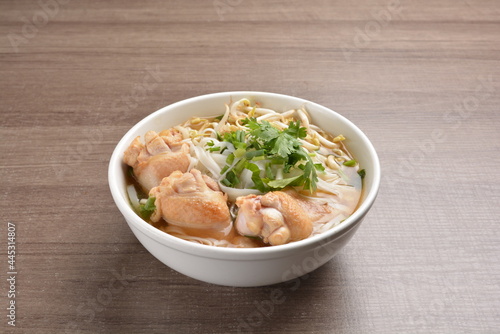 cook clear hot soup with chicken meat, vegetable and noodle on wood background asian halal menu