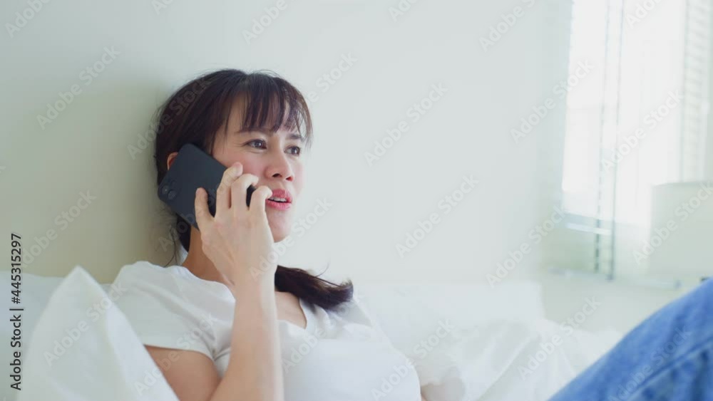Asian attractive woman use mobile phone call on bed at home in morning Asian attractive woman use mobile phone call on bed at home in morning