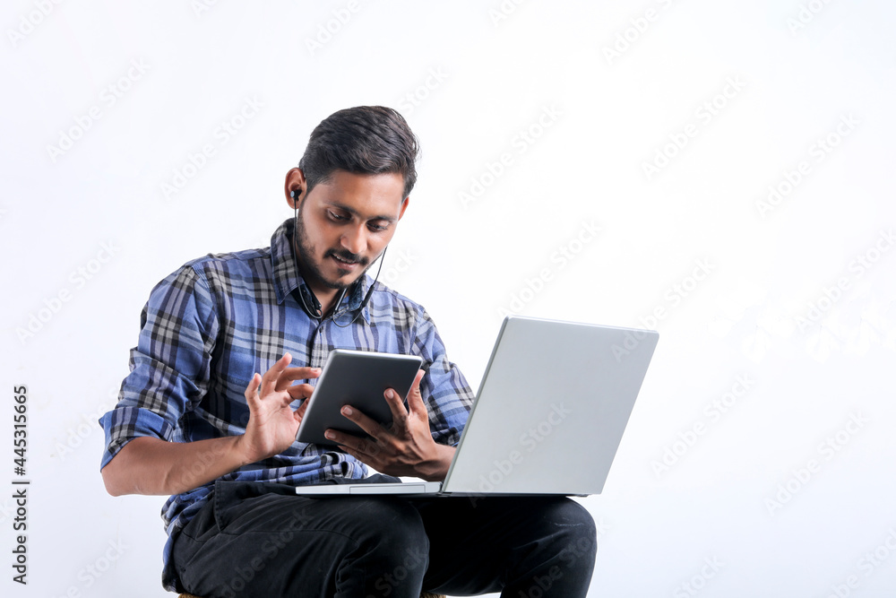 Young indian man using laptop over white background. Young indian man using laptop over white background.