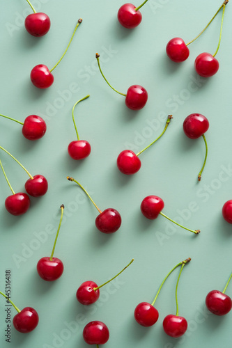 Cherry pattern. Flat lay of cherries on a green background. Top view