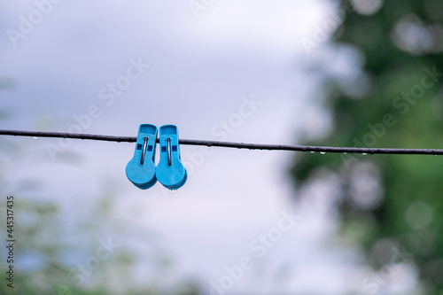 Double blue clothespins on cables on a rainy day