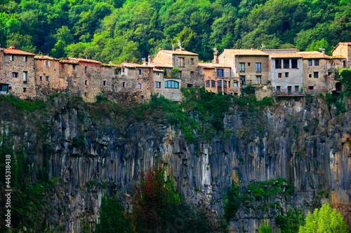 Castellfollit de la Roca, Garrotxa, Province of Girona, Catalonia, Spain, Europe. Beautiful scenic view, ancient town houses over the huge basalt cliff and mountain covered with green wood
