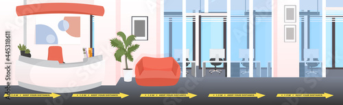 lobby entrance reception desk with signs for social distancing yellow stickers coronavirus epidemic protection