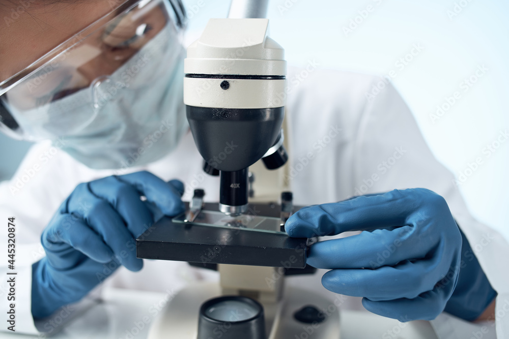 Woman in white coat laboratory science microscope analyzes Woman in white coat laboratory science microscope analyzes