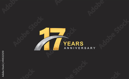 17th years anniversary logo with golden ring and silver swoosh isolated on black background, for birthday and anniversary celebration.