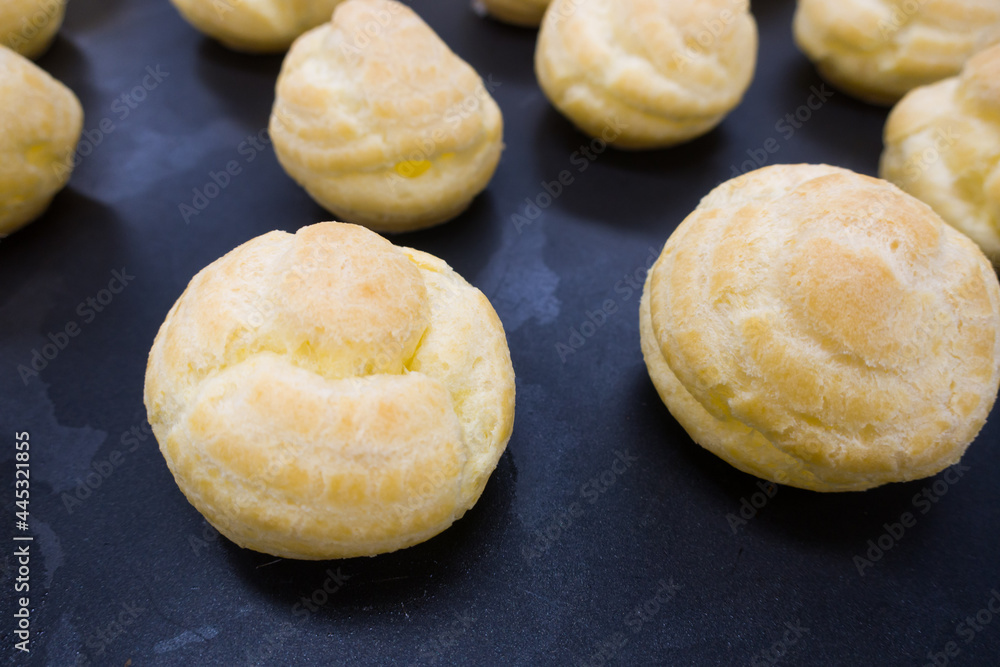 cream puffs aligned closeup isolated on black background.
