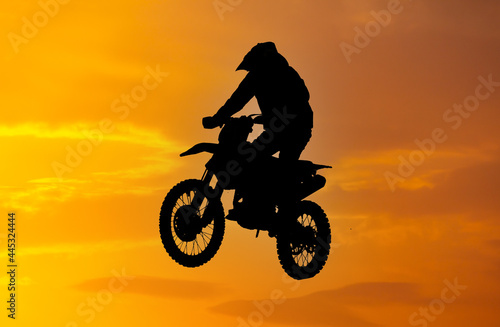 Silhouette of a man on a motorcycle against the background of a golden