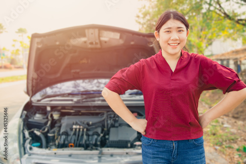 Portrait Happy women standing front of broken accidents car open hood smiling waiting car insurance at roadside with no worry. © Quality Stock Arts