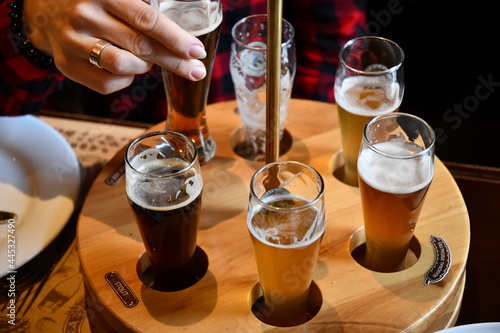 Photography Female hand takes glass of craft beer in pub to make toast cheers