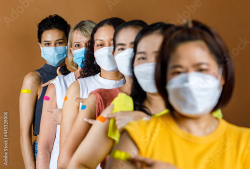 Leinwand Poster Diverse group of multinational ethnic female patients wears face mask stand in l
