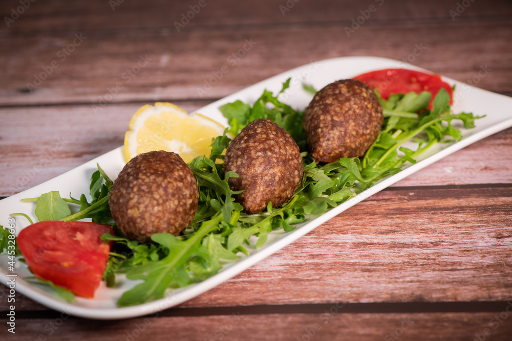Traditional kebbe and pita bread on big round plate in lebanese restaurant. High quality photo Traditional kebbe and pita bread on big round plate in lebanese restaurant. High quality photo