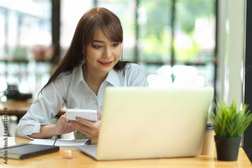 Female accountant working with laptop and calculator at cafe Female accountant working with laptop and calculator at cafe