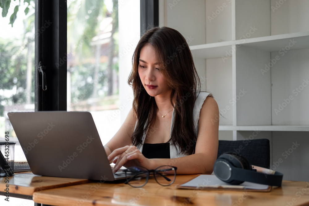 Obraz premium Asian woman using laptop computer with headset at home, Online learning education concept