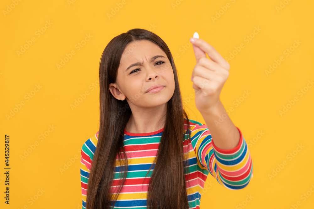curious child look at pill. capsule shape tablet for kids. girl hold multivitamin. curious child look at pill. capsule shape tablet for kids. girl hold multivitamin.