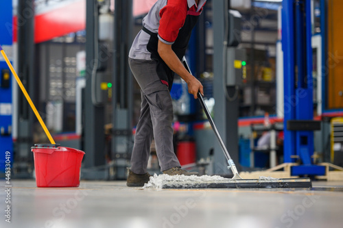 Photography Car mechanic cleaning the garage floor at the auto industry shop workshop Use a mop to clean water from the epoxy floor in the car repair center
