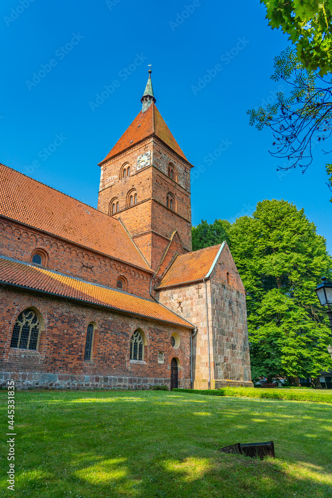 Old Alexander Church in Wildeshausen with green trees and blue sky