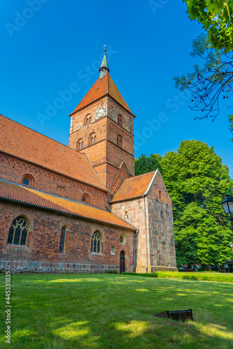 Old Alexander Church in Wildeshausen with green trees and blue sky