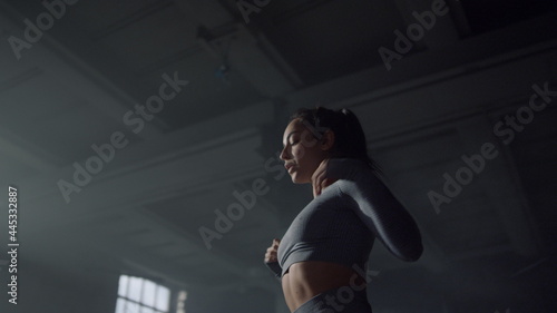 Girl preparing body for strength exercises. Bodybuilder warming shoulders 