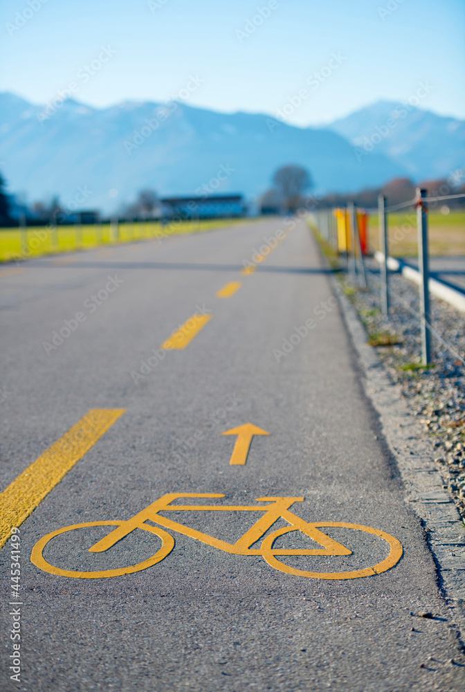 Obraz premium Cycling Lane on the Side of a Road with Mountain in a Sunny Day in Locarno, Ticino in Switzerland.