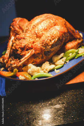 Whole baked golden crispy chicken in a pan cooked with potatoes