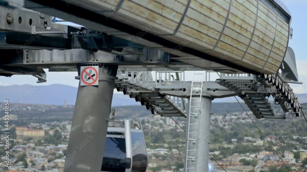 Riding modern aerial railway with sign Dont smoke on pole Riding modern aerial railway with sign Dont smoke on pole