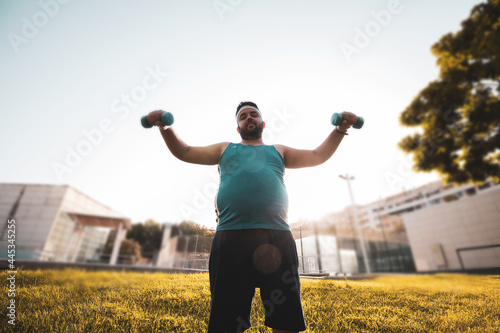 Foto a fat young man doing weights outdoors.
willpower.