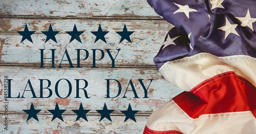 Digitally generated image of american flag and happy labor day text against wooden background