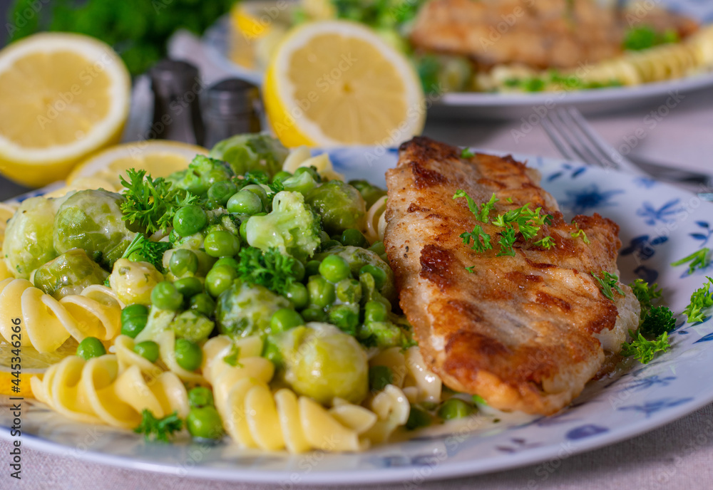 Fish with pasta and vegetables served with bechamel sauce on a plate Fish with pasta and vegetables served with bechamel sauce on a plate