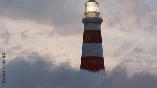 illuminated lighthouse over fluffy clouds in the beautiful sunset