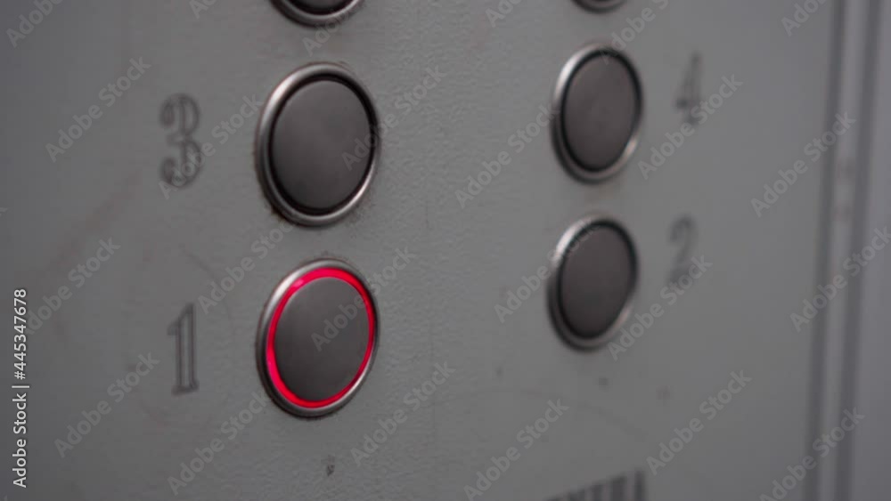 A man in a shabby old elevator presses the button for the first floor. A live camera, it feels unsettling. A man in a shabby old elevator presses the button for the first floor. A live camera, it feels unsettling.
