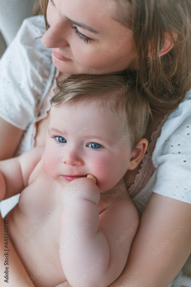 A beautiful young mother with a blue-eyed little daughter are resting at home. Cozy. A beautiful young mother with a blue-eyed little daughter are resting at home. Cozy.