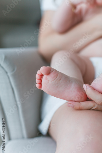 Close-up of baby's feet in mom's. Baby. Home. Cozy.